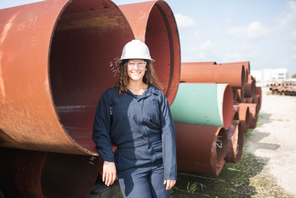 Female engineer smiling in front of pipe